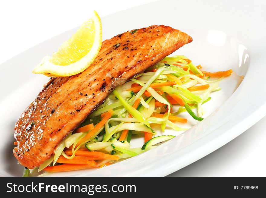 Fillet of Salmon with Julienne Peeler Vegetable and Lemon Slice. Isolated on White Background