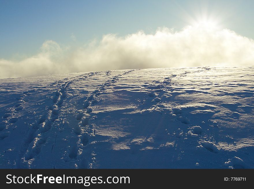 Footprint in the snow going to the sun. Footprint in the snow going to the sun