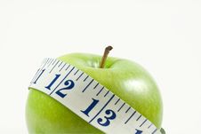 Green Apple Wrapped By A Measuring Tape Royalty Free Stock Images
