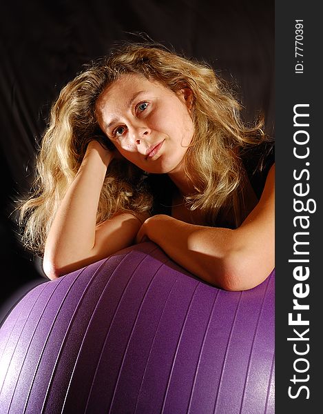 Portrait of a beautiful young woman lying on a big fitness ball. Portrait of a beautiful young woman lying on a big fitness ball