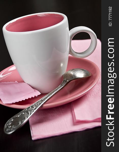 Pink cup on a plate and spoon