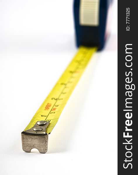 Measuring tape extended towards viewer with very shallow depth of field. Isolated on white. Measuring tape extended towards viewer with very shallow depth of field. Isolated on white.