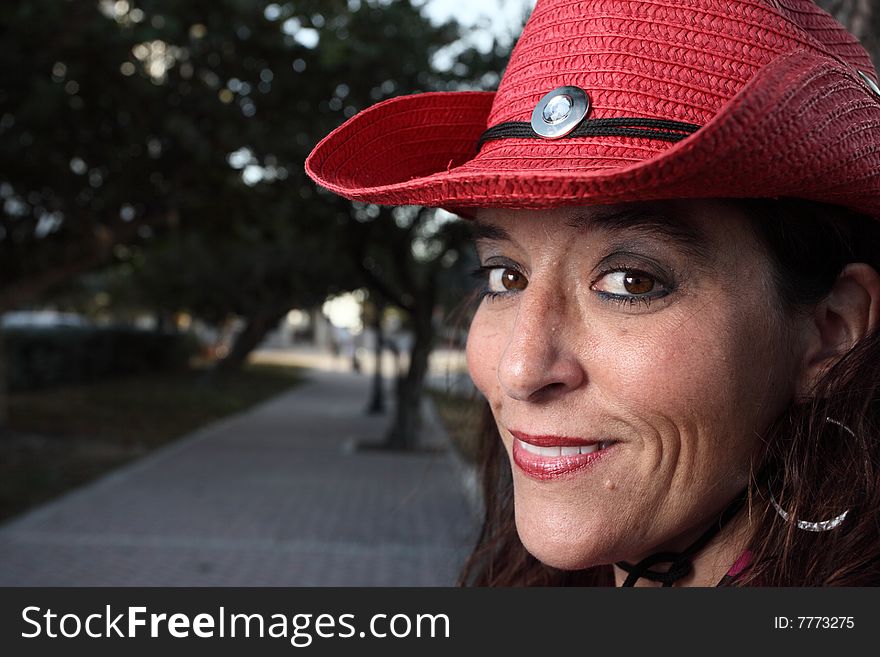 Cowgirl wearing a red hat. Cowgirl wearing a red hat