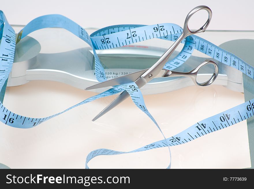 Concept image of scissors cutting tape measure symbolizing weight lost. Concept image of scissors cutting tape measure symbolizing weight lost