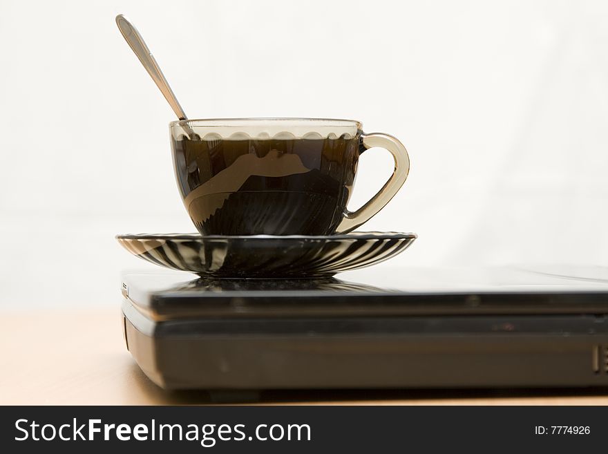 Espresso coffee cup with steel spoon on the laptop