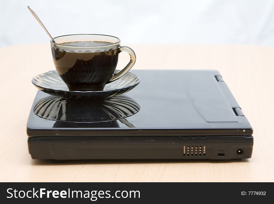 Espresso coffee cup with steel spoon on the laptop