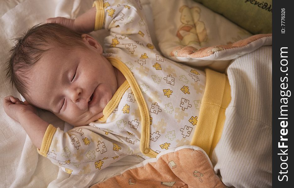 Newborn baby lying on its back, spread arms and sleeping. Newborn baby lying on its back, spread arms and sleeping.