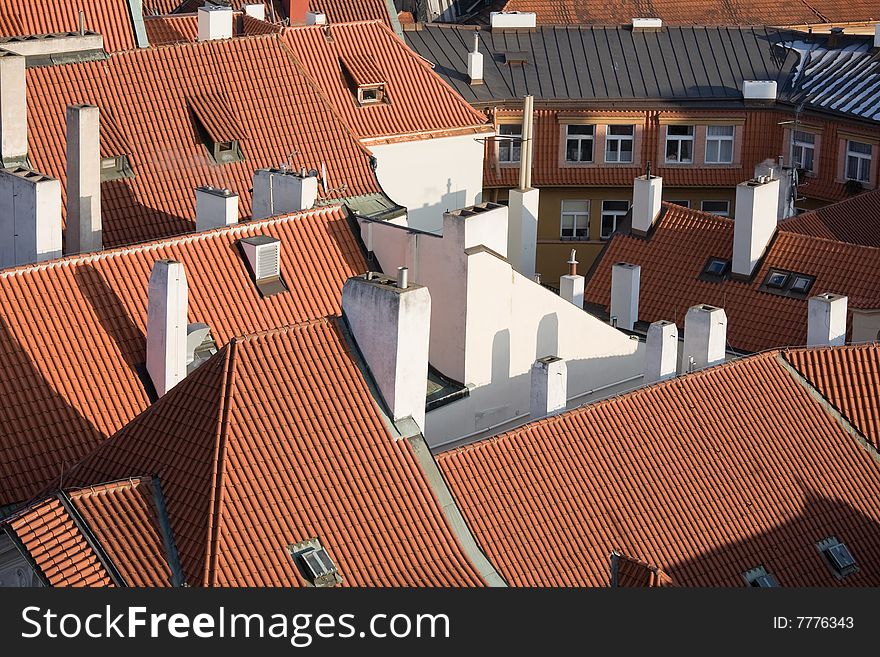 Typical Prague red roofs with white chimneys.