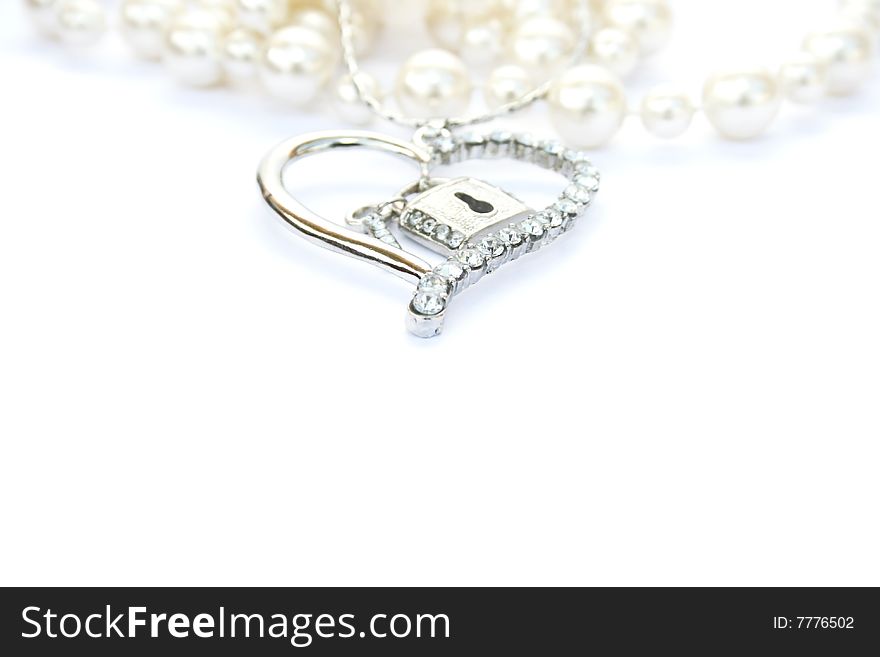 Silver heart with key,lock,pearls on white background.