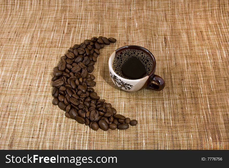 Coffee beans and cup close-up isolated on a beige sacking