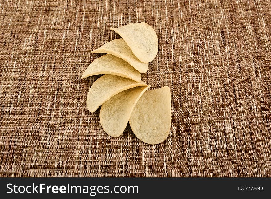 Potato chips close-up isolated on a brown sacking