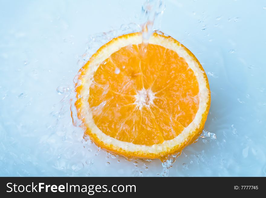 Water pouring over half orange