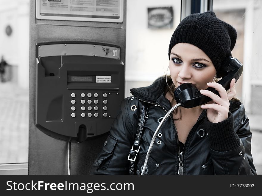 The young girl in telephone booth calling