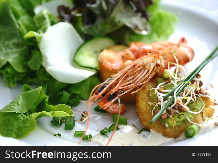 Starter plate containing prawns, shrimps, sprouts and chopped onions on a bed of lettuce