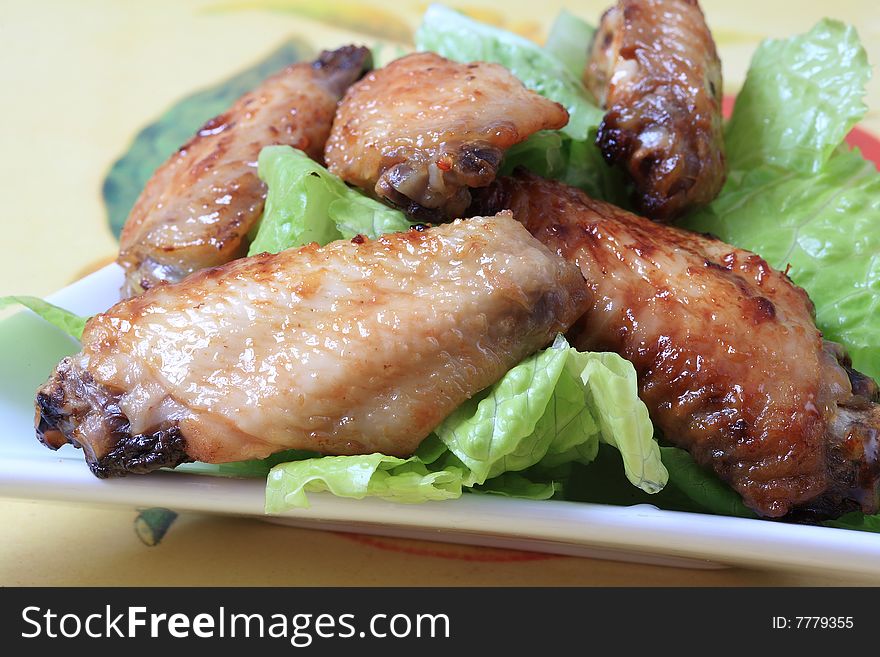 Grilled chicken wings with hot pepper sauce and salad