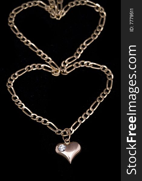 Small gold chain and heart with diamond on black