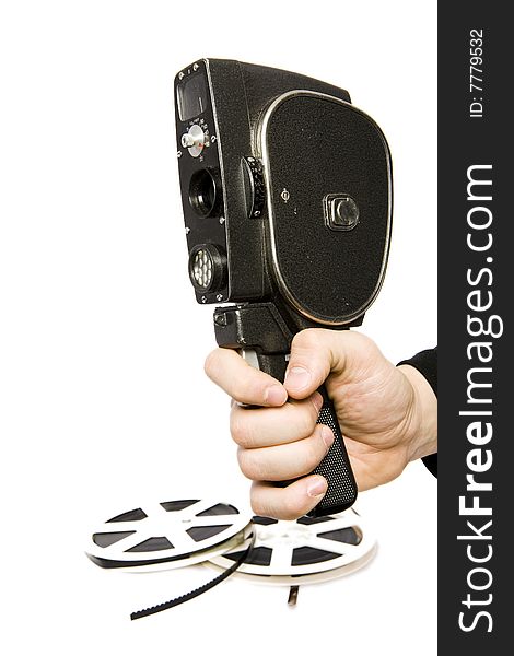 Man hand with old movie camera and two reels of film on background