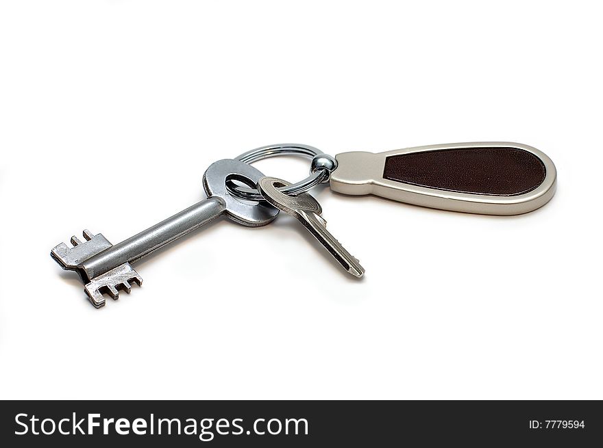 Two keys on a charm. It is isolated on a white background. Two keys on a charm. It is isolated on a white background