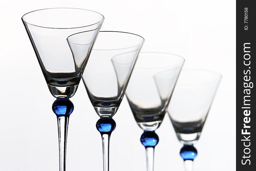 Four blue wineglasses against the white background
