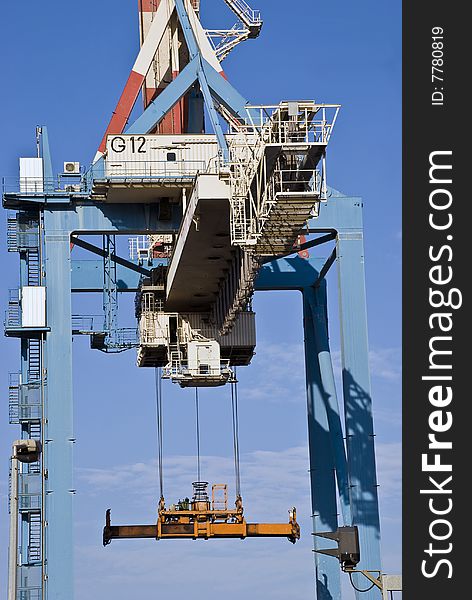 Heavy industrial crane used to load and unload large cargo ships at a port. Heavy industrial crane used to load and unload large cargo ships at a port