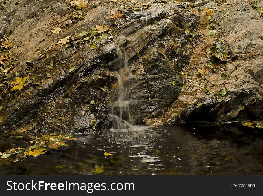 Waterfall,rocks, and boulders in California canyon with pool at base. Waterfall,rocks, and boulders in California canyon with pool at base.