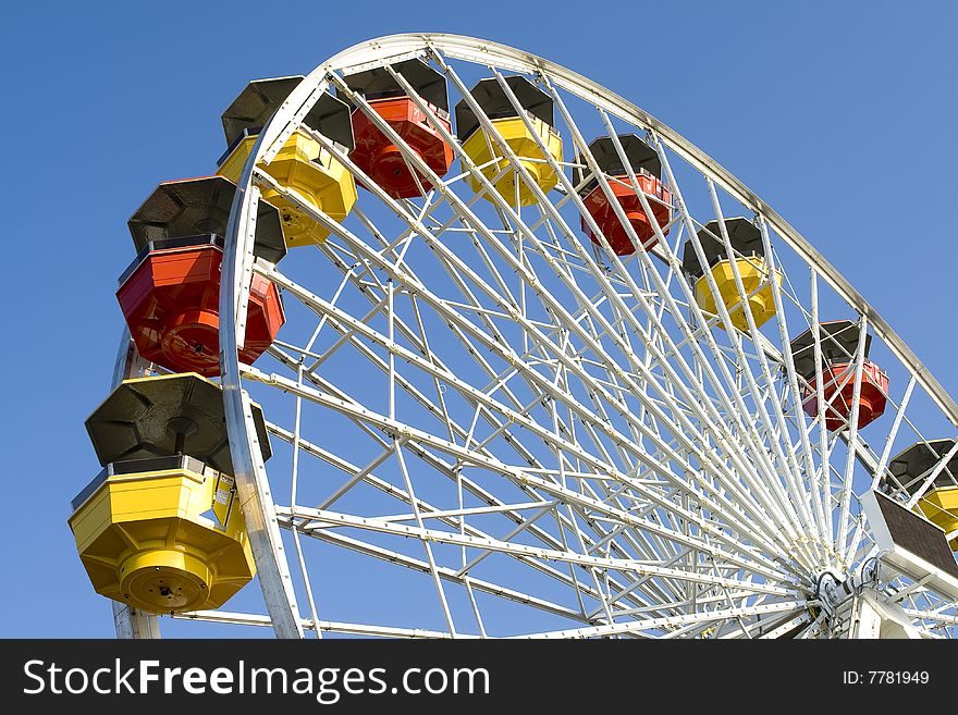 Ferriswheel in amustment park against sunny, blue sky.