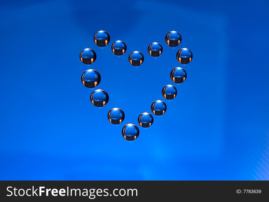 Water drops in the form of heart on a celebratory background