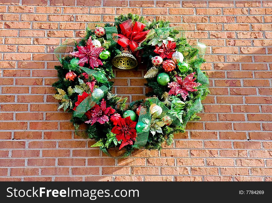 A christmas wreath on a brick wall in the sunlight. A christmas wreath on a brick wall in the sunlight