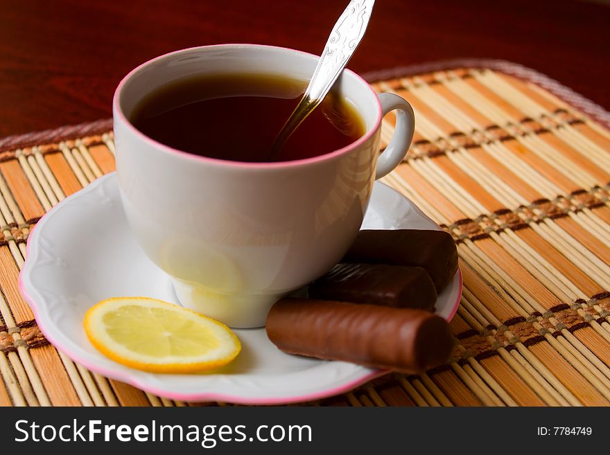 Cup of black tea with lemon and sweets. Cup of black tea with lemon and sweets