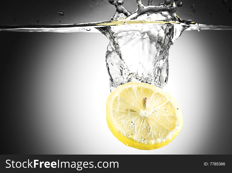 Abstract water background. Yellow lemon falling in water with splashes. Abstract water background. Yellow lemon falling in water with splashes