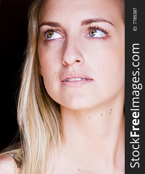 Blond praying woman against black background