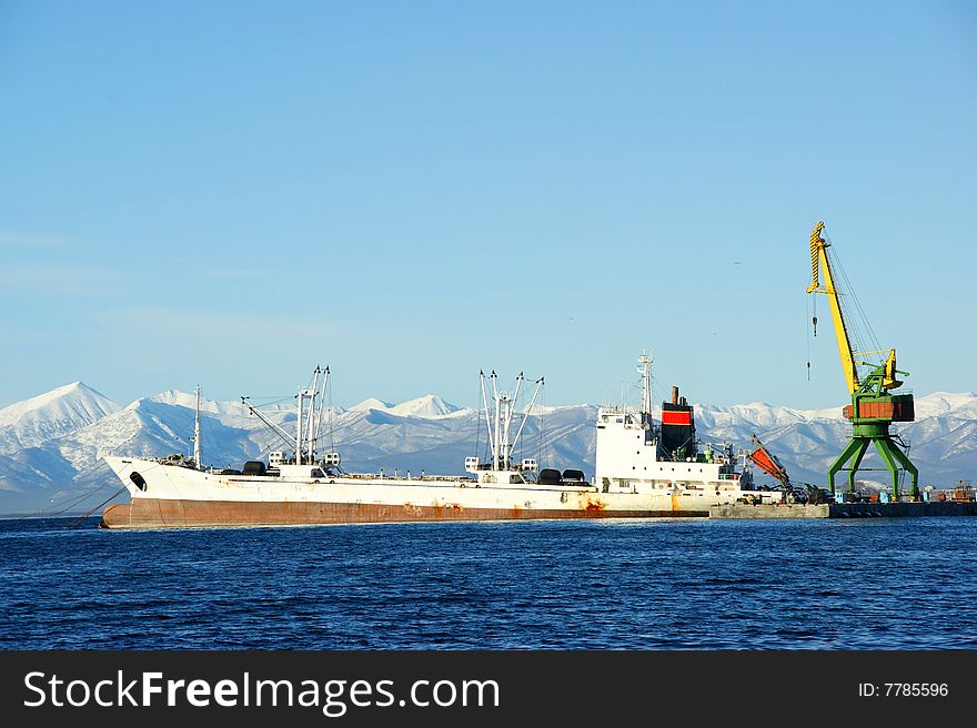 Tap loads ship on background of the mountains