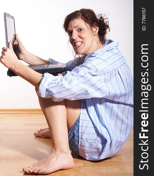 A young woman at home with her laptop sitting on the floor in her new appartment. She seems to be very frustrated. A young woman at home with her laptop sitting on the floor in her new appartment. She seems to be very frustrated.