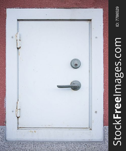 Very small white metal door with lock and handle. Very small white metal door with lock and handle.