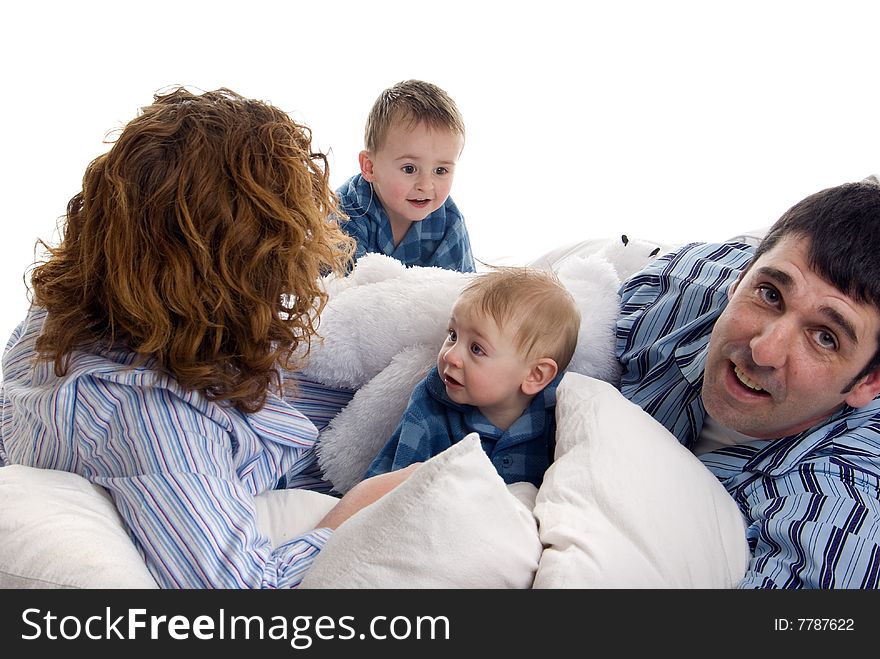 Family of four relaxes in bed