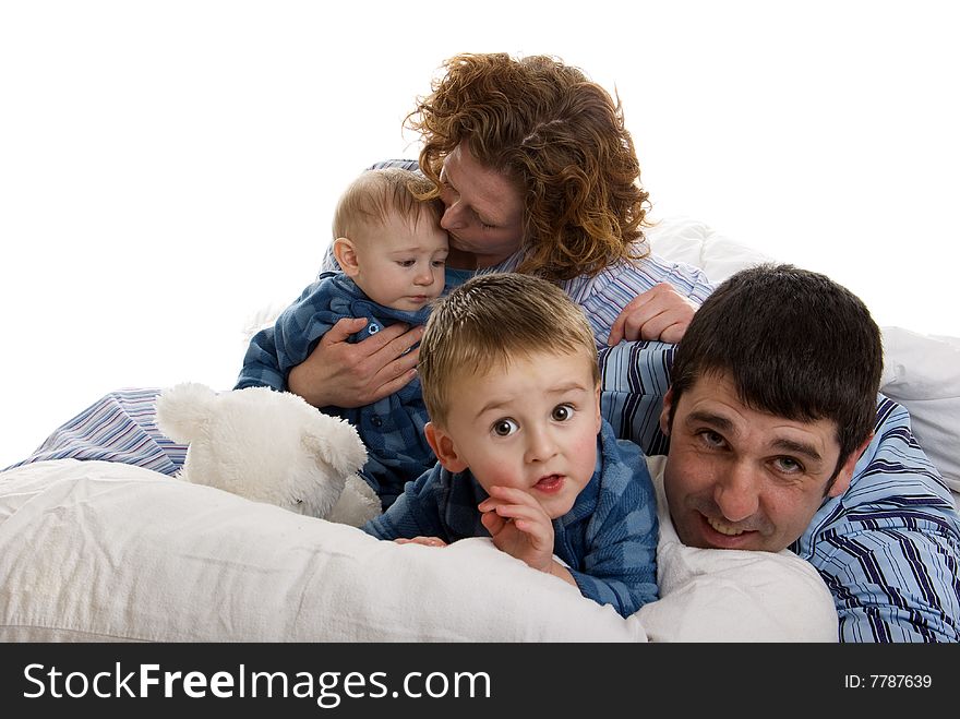 Family of four wakes up and relaxes in bed. Family of four wakes up and relaxes in bed