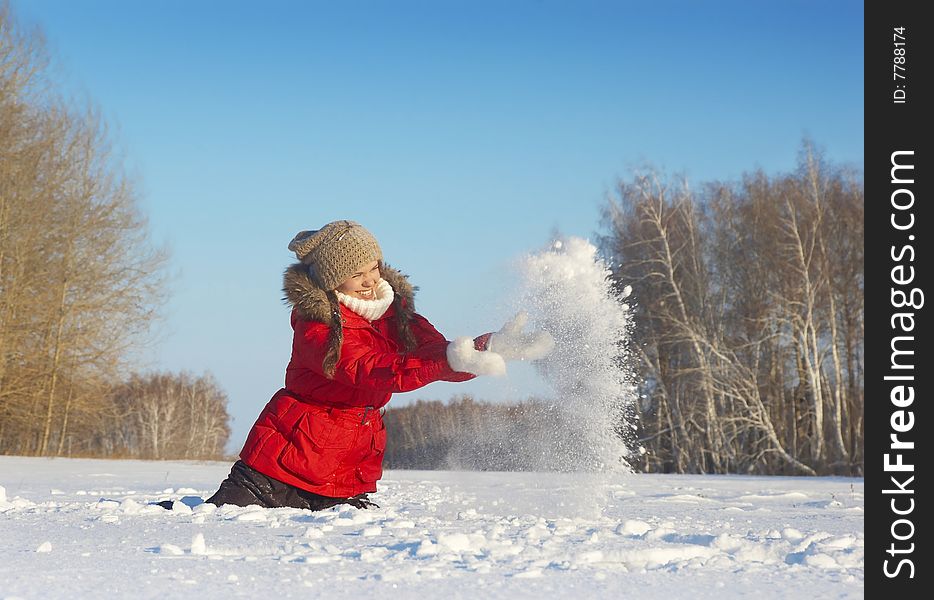 The young girl in a winter jacket sits on snow. The young girl in a winter jacket sits on snow