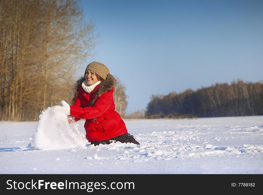 The young girl in a winter jacket sits on snow. The young girl in a winter jacket sits on snow