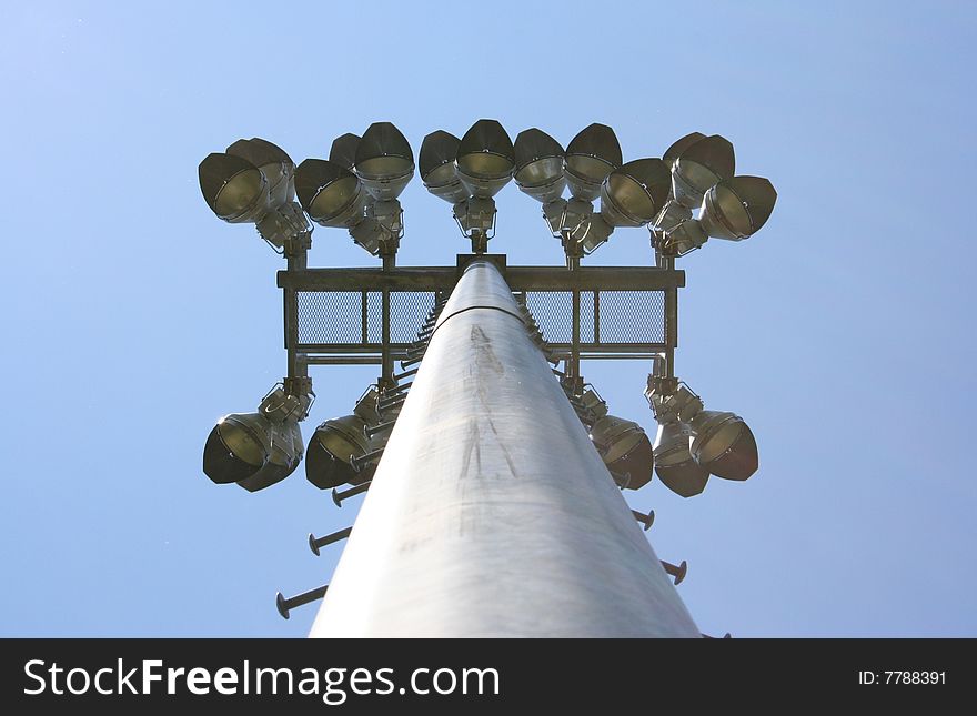 Stadium-style lights, taken at sports fields at a park, looking up, clear blue sky background, daytime so the lights are off. Stadium-style lights, taken at sports fields at a park, looking up, clear blue sky background, daytime so the lights are off.