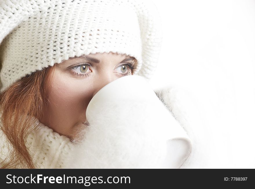 The beautiful young woman in a white sweater and winter cap. The beautiful young woman in a white sweater and winter cap