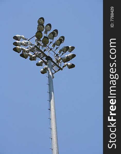 Stadium-style lights, taken at sports fields at a park, looking up, clear blue sky background, daytime so the lights are off. Stadium-style lights, taken at sports fields at a park, looking up, clear blue sky background, daytime so the lights are off.