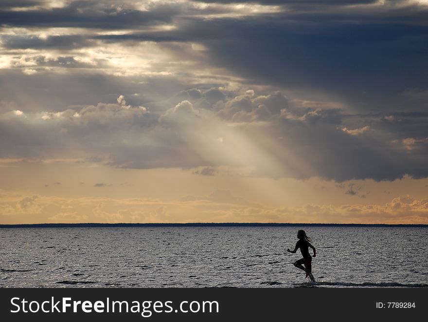 A girl running in the water at evening. A girl running in the water at evening