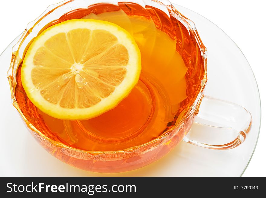 Glass cup with tea and a lemon on a white background