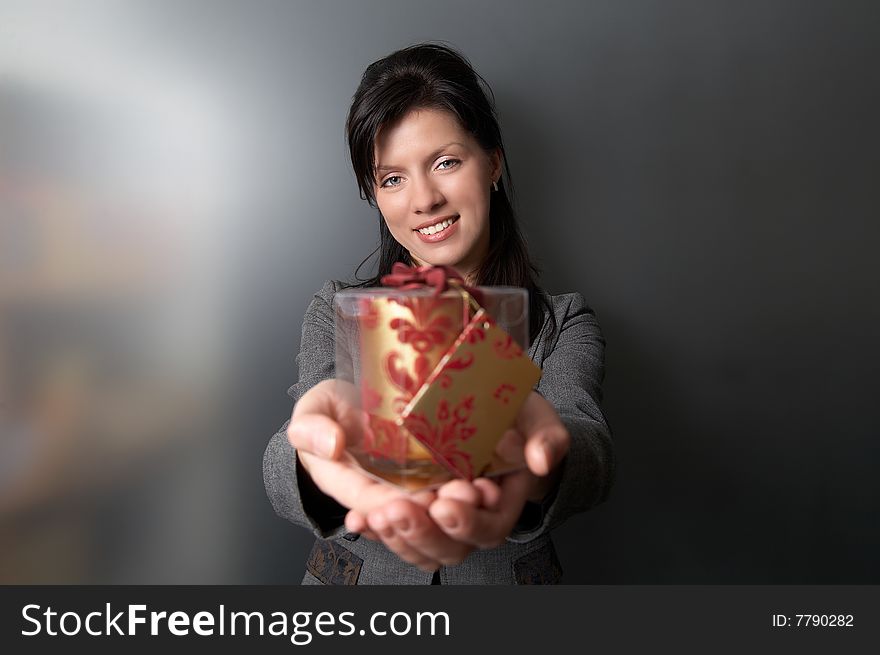 Young pretty caucasian woman is holding a red present. Young pretty caucasian woman is holding a red present