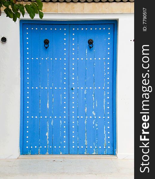 Traditional blue wooden house door with knockers in Monastir Medina, Tunisia. Traditional blue wooden house door with knockers in Monastir Medina, Tunisia.