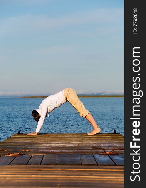 Yoga Woman on a dock by the ocean