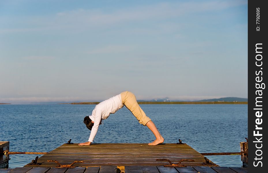 Yoga Woman on a dock by the ocean