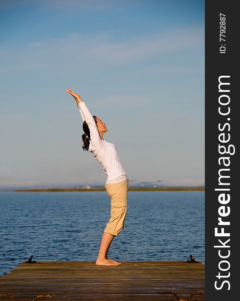 Yoga Woman on a dock by the ocean