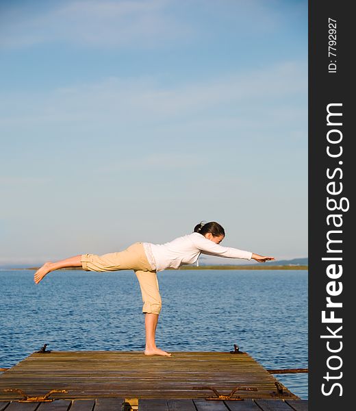 Yoga Woman on a dock by the ocean