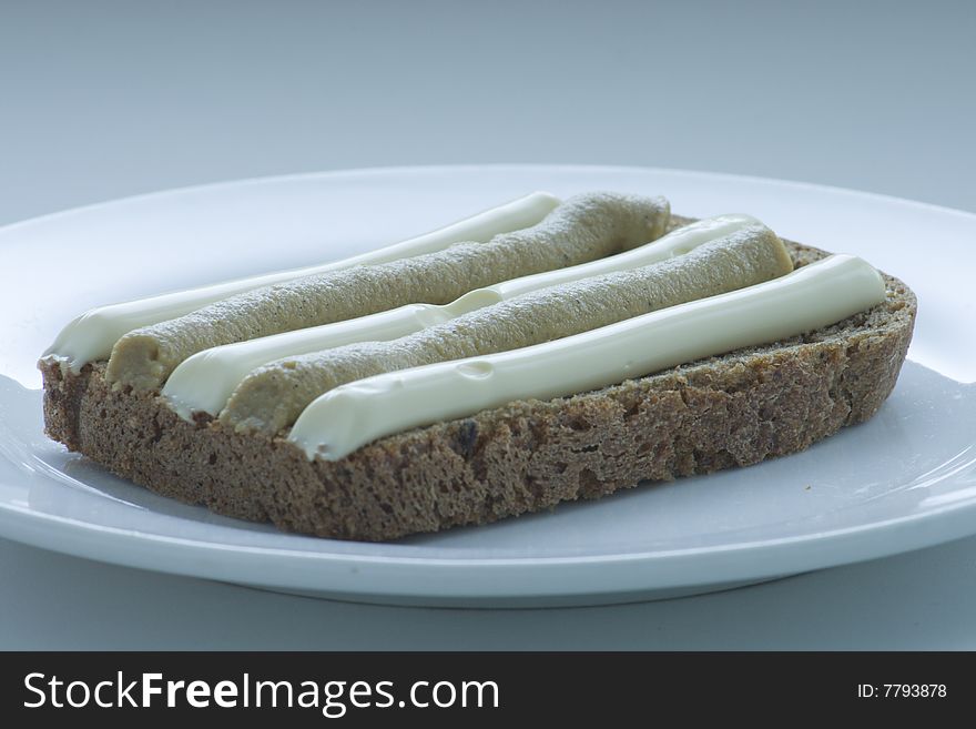 Black bread with mayonnaise and mustard on a plate. Black bread with mayonnaise and mustard on a plate